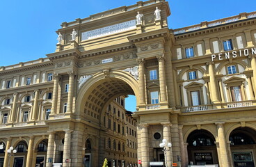 Obraz premium The architectural grandeur and beauty of the arched building in Piazza della Repubblica in Florence under the rays of the summer sun.
