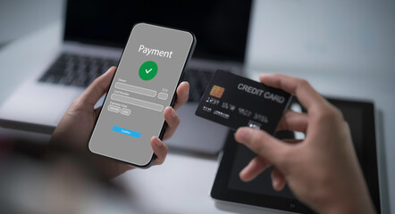 Payment successful concept.Hand holding credit card and smartphone with Payment successful.Online Money Transfer Confirmed.Concept of e-commerce and online banking, payment transfer