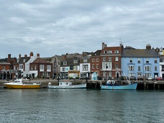 Obraz premium Old buildings and boats in the harbour of Weymouth, England, United Kingdom, July 2023