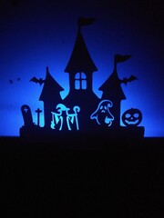 a shadow silhouette of a papercut craft of a spooky house