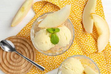 Scoops of melon sorbet with mint in glass dessert bowls, fresh fruit and spoon on white wooden table, flat lay