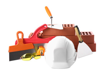 Hard hat, red bricks, trowel, measuring tape, goggles and putty knives isolated on white. Building...