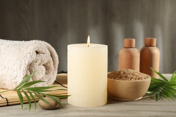 Spa composition with burning candle on wooden table
