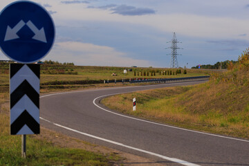 Wide road, highway, sun and blue sky on a summer day.