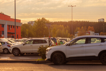 Autumn landscape and view of the road with cars. Orange evening sun and reflections on cars.