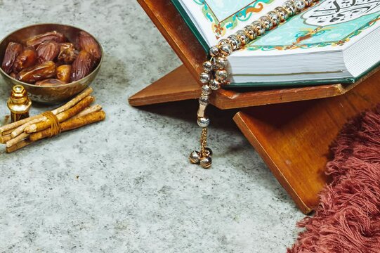 lantern and Holy Quran with Arabic calligraphy meaning of Al Quran and prayer mat , rosary muslim and dates fruits