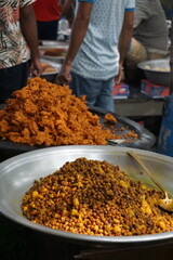 Mix vegetable pakora making and being displayed by a street food vendor, Crispy onion and potato pakoda selling on a market, Spicy veg pakora or pakoda displayed on a rural fair for sale