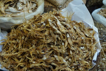 Mixed dried fish are displayed and sold at a fish market, Different types of dried fish are sold by...