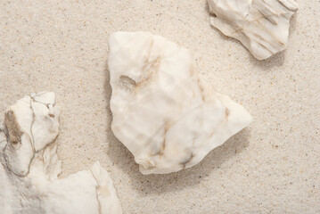Natural background. White rocks on the sand.