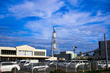 港の近くの近代的な発電所と高い煙突と青い空、雲