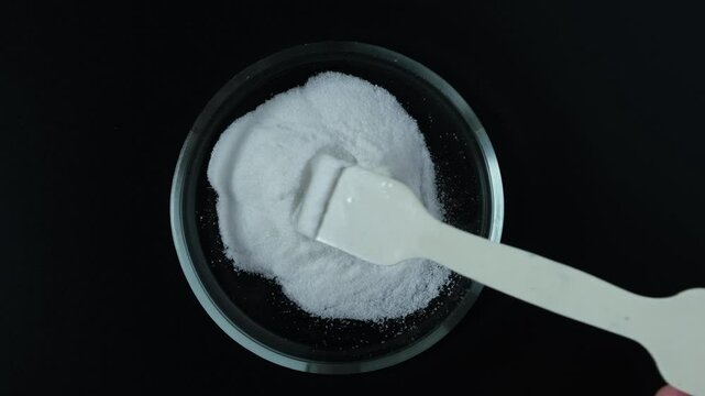 Food additive E316 in Petri dish. Sodium salt of erythorbic acid. Sodium erythorbate or isoascorbate powder. Chemical formula C6H7NaO6. Often added in processed meat such as hot dogs and beef sticks.