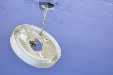 An old broken lampshade for a chandelier hanging from the ceiling