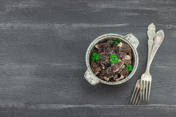 Raw black morel mushrooms with fresh parsley. Vegan ingredient for cooking healthy food