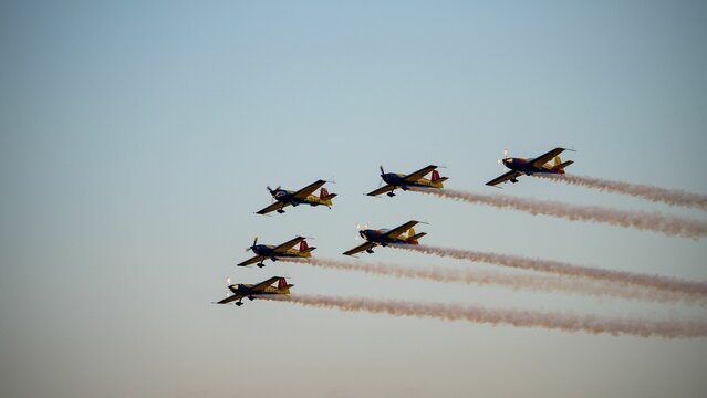 Aerobatic planes in formation at an airshow.