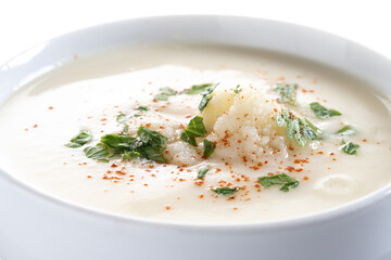 Cauliflower soup in bowl isolated on white background.