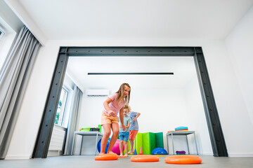 Kids group physio therapy. Children exercising during session. Bilateral coordination or...