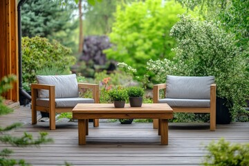 Obraz premium An inviting outdoor deck featuring two cushioned chairs and a wooden table with lush green plants, creating a cozy and peaceful space to unwind and relax.