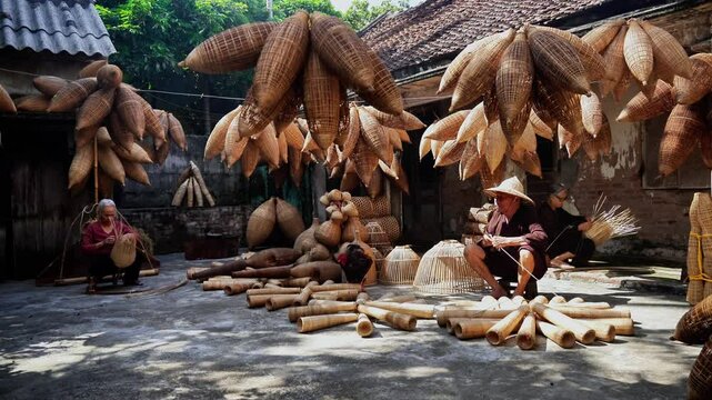 View of Vietnamese craftsman making the traditional bamboo fish trap or weave at the old traditional house in Thu sy trade village, Hung Yen, Vietnam