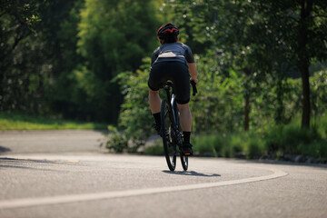 Woman cyclist riding bike at summer park