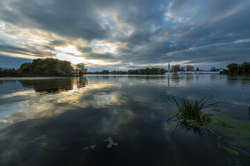 A calm lake with a cloudy sky in the background