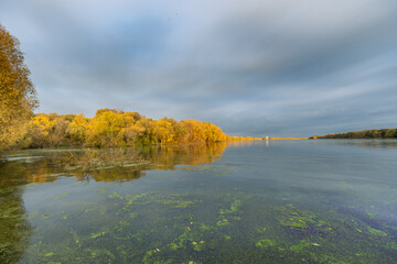 A lake with a cloudy sky in the background