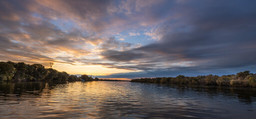 The sky is a beautiful mix of orange and blue hues, creating a serene