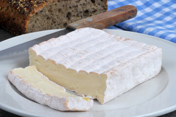Fromage Vieux Pané coupé dans une assiette avec un couteau et du pain en gros plan