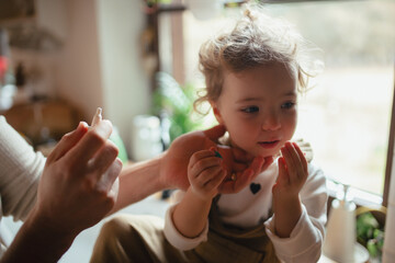 Sick girl with cold at home has stuffy nose. Father helping little daughter to breath better, using...