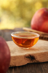 A bowl of apple cider vinegar with fresh apples