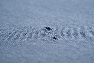 close-up of a hole on a blue jersey, a hole on a gray macro T-shirt 