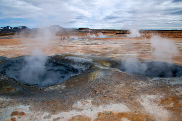 Myvatn Iceland, view across colourful landscape with mud pools and steam vents at Namafjall or Hverir geothermal area with car park in background