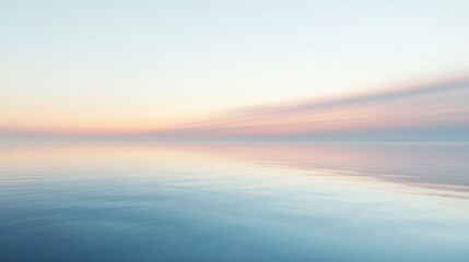 Obraz premium Calm blue water with a faint pink and orange sunset reflected in the surface.