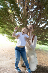 Fototapeta premium A woman and a child are standing in a forest
