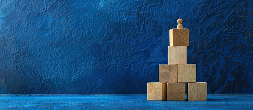Wooden blocks showcase a team player symbol against a scenic deep blue backdrop emphasizing the business concept with a cop space image. with copyspace image