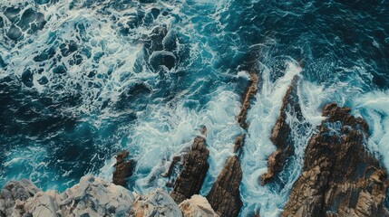 Obraz premium Ocean waves rolling to the rocky shore Beautiful seascape Aerial top view of the beautiful ocean rocky shore with rolling waves Drone is hovering over rolling ocean waves to rocky shore