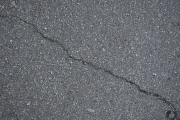 cracks on grey asphalt, repair of old road surface as background, wet pavement texture, gray asphalt texture with red and white gravels	
