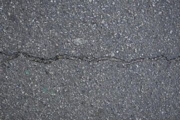 cracks on grey asphalt, repair of old road surface as background, wet pavement texture, gray asphalt texture with red and white gravels	
