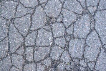 old cracked asphalt close-up, old cracked symmetrical pavement as a background, cracks on macro asphalt