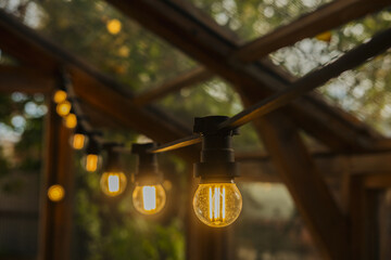 Warmly lit string lights create an inviting atmosphere in a wooden outdoor space