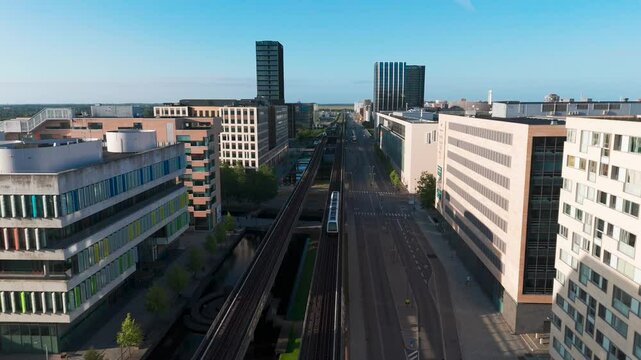 Flying above main Orestad metro railway line through residential area, Denmark