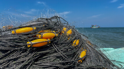 Close-up of tangled fishing nets with yellow floats on a boat, highlighting coastal livelihood and environmental sustainability