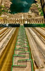 Tall dam with zigzag staircase symbolizes infrastructure challenges in water management,...