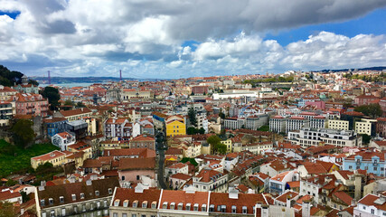 Fototapeta premium Vibrant cityscape of Lisbon, Portugal, showcasing colorful architecture under dramatic clouds, ideal for travel and tourism themes
