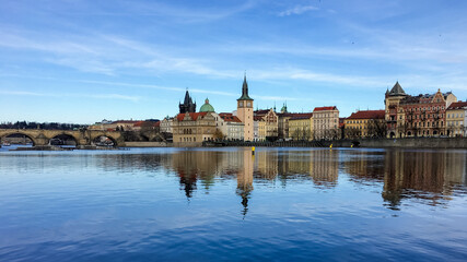 Scenic view of Prague's historic skyline and Charles Bridge reflecting on the Vltava River, evoking travel and cultural heritage