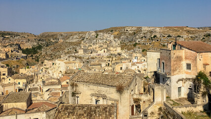 Fototapeta premium Ancient stone dwellings in Matera, Italy, under a clear blue sky, embody rich European history and cultural heritage tourism