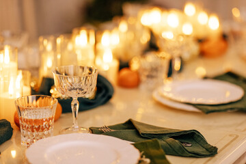 A cozy stylish living room with a covered table and a decorated Christmas tree with a garland.