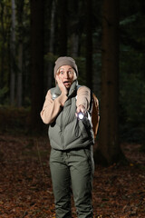frightened woman in the forest with a flashlight. horror movie concept. dark forest. lonely wanderer