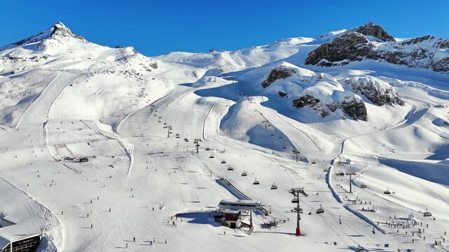 Ischgl, Austria: Aerial view of famous bustling ski resort in Tyrolean Alps. Snow-covered slopes with ski runs, sunny day with clear blue sky - landscape panorama of Europe from above
