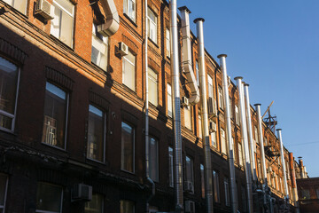 industrial architectural background, pipelines on the facade of vintage factory building