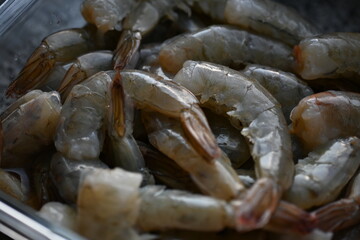 close-up of grey fresh raw prawns, carcasses of fresh grey thawed prawns, prawn tails fresh for cooking 